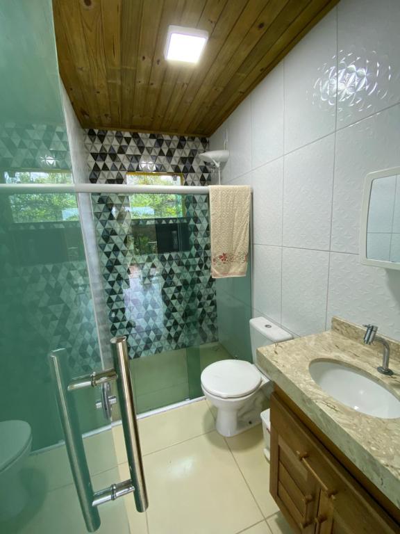 a bathroom with a toilet and a sink at Residencial Sítio Paraíso in Itacaré