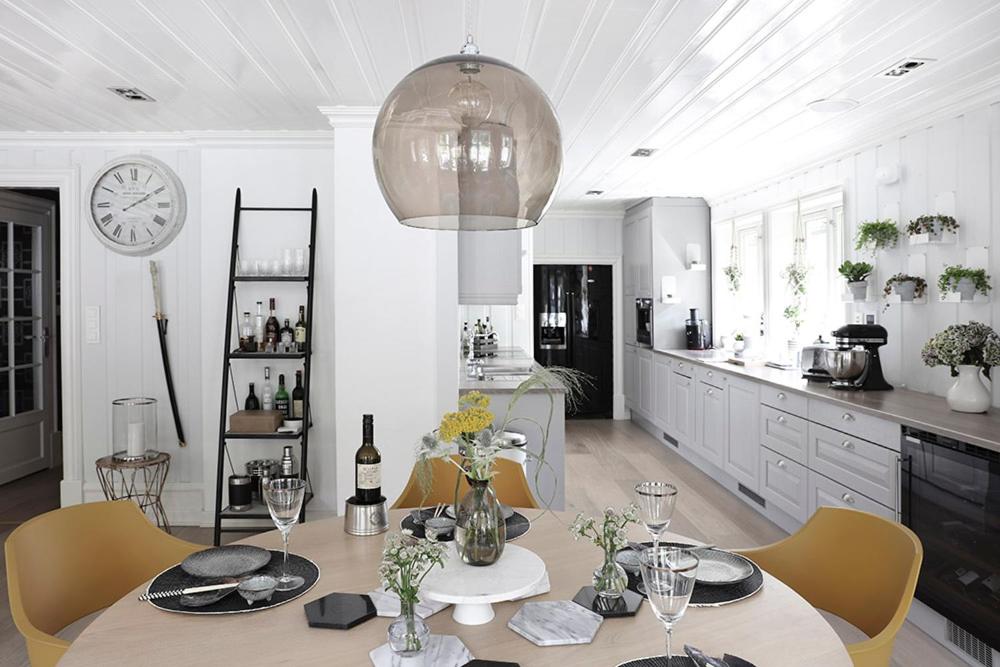 a kitchen with a table and chairs and a clock at Villa Marikollen in Hektner