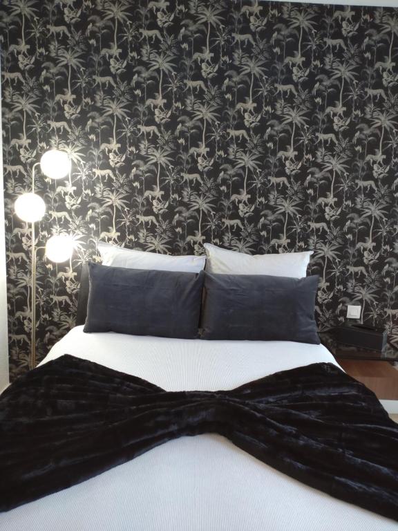 - une chambre avec un lit et du papier peint noir et blanc dans l'établissement Suite Privée à Bordeaux Caudéran, à Bordeaux