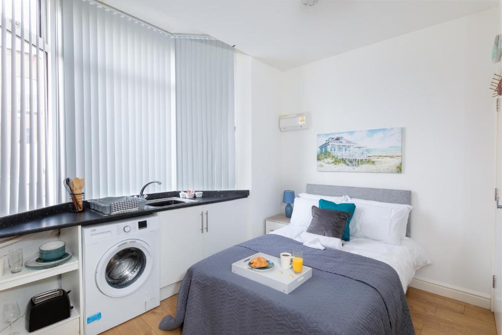 a bedroom with a bed and a washing machine at No 1 Thornhill House in Hartlepool