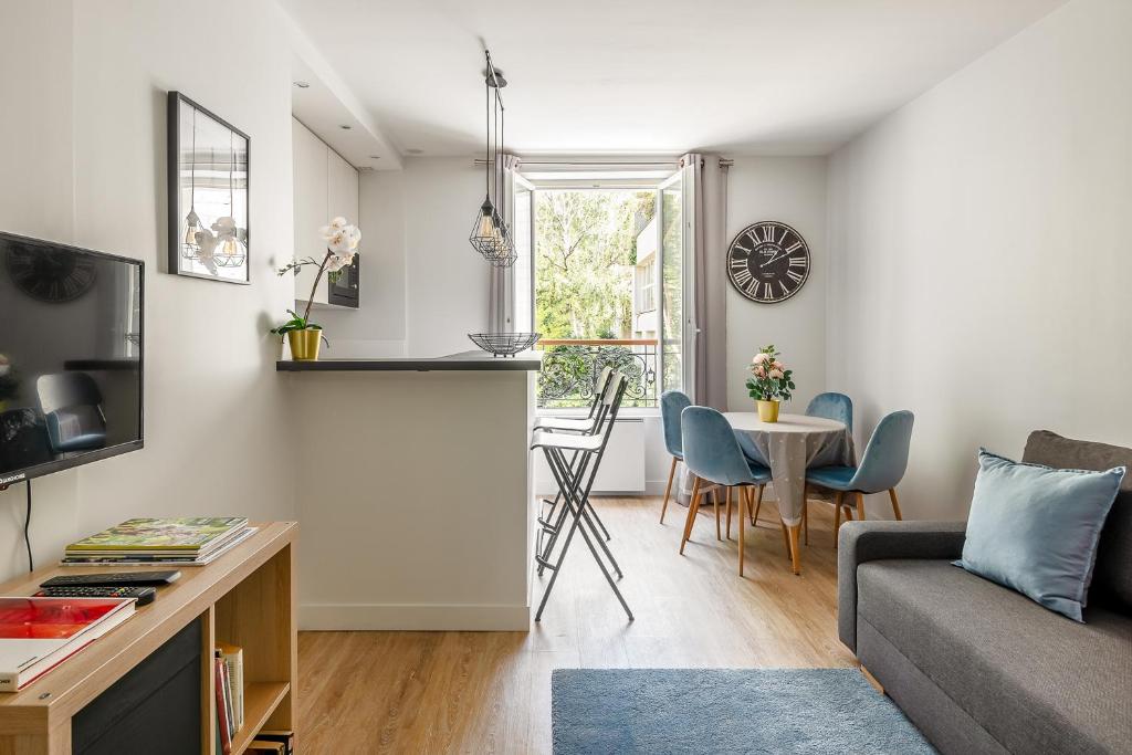un salon avec un canapé et une table dans l'établissement 1 bedroomed Apartment Repos, à Paris