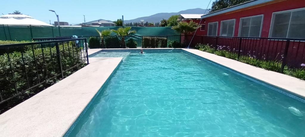 的住宿－Cabañas Rancho Carmelitas, Pullally, localidad agrícola de Papudo，一座房子前面的蓝色海水游泳池