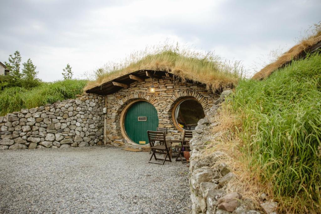 un edificio con techo de hierba, mesa y sillas en Mayo Glamping, en Castlebar