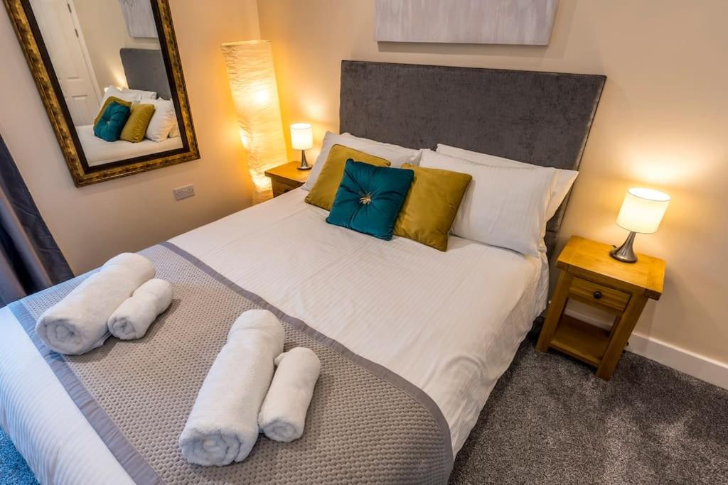 una camera da letto con un grande letto con asciugamani di Cosy Cottage in Central Kendal with Parking! a Kendal
