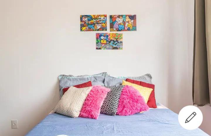 una cama con almohadas coloridas encima en Apartamento Copacabana, en Río de Janeiro