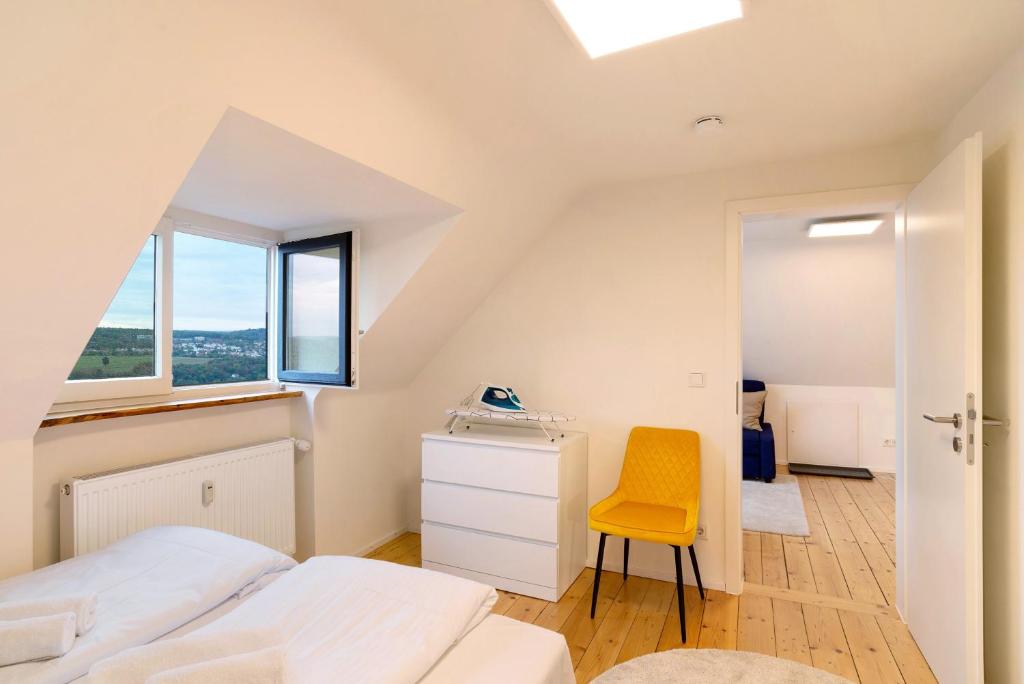 ein Schlafzimmer mit einem Bett und einem gelben Stuhl in der Unterkunft Charmante Dachgeschosswohnung in Pforzheim