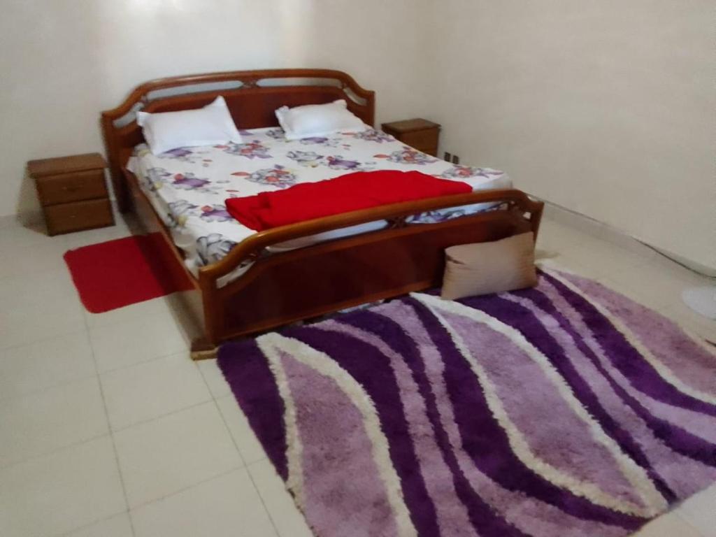 a bedroom with a bed with a purple rug at Free Studio in Dakar