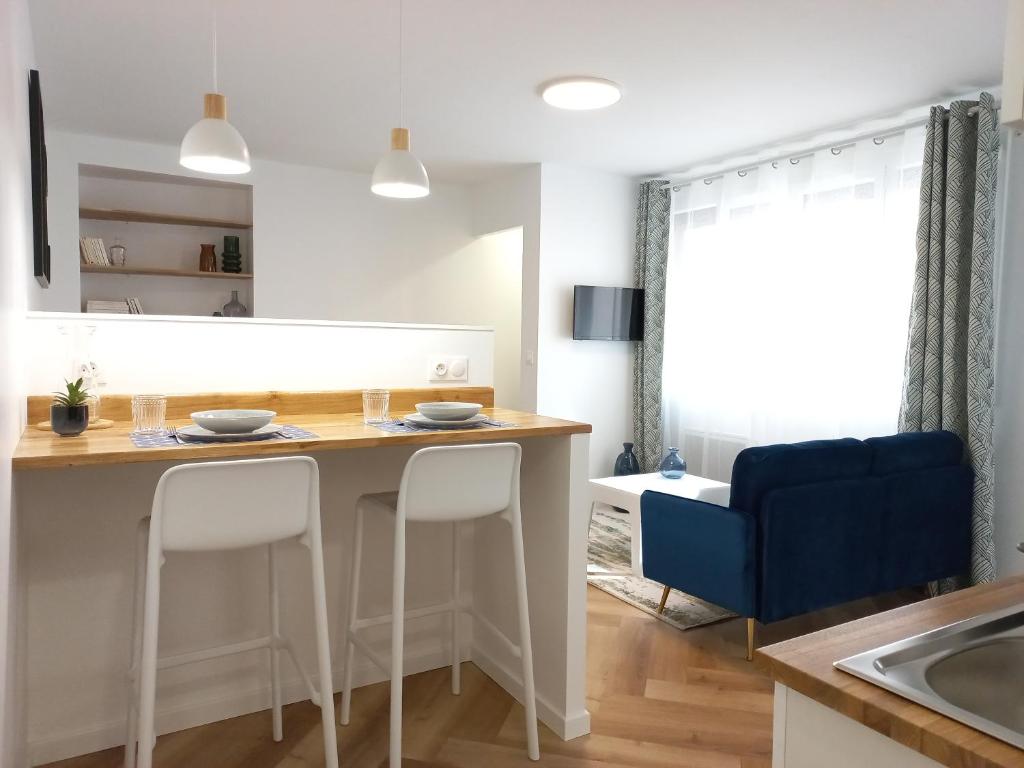 a kitchen with a table and two stools at Cosy &amp; Chic - Hyper centre - Wifi - Proche gare in Châteauroux