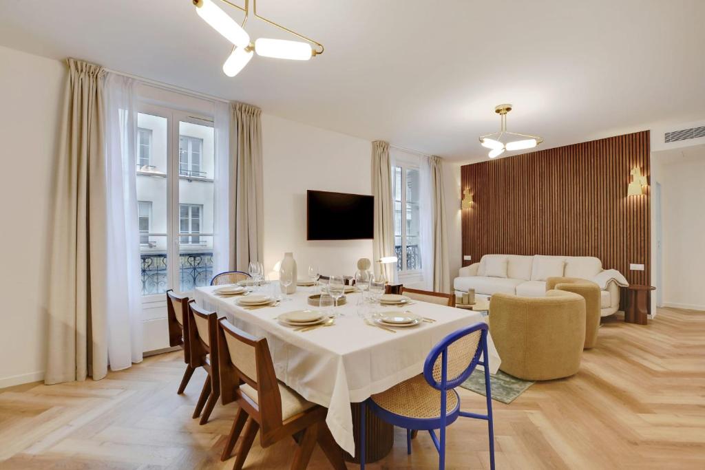 a dining room and living room with a table and chairs at Stunning fully renovated apartment 8P Paris 11 in Paris