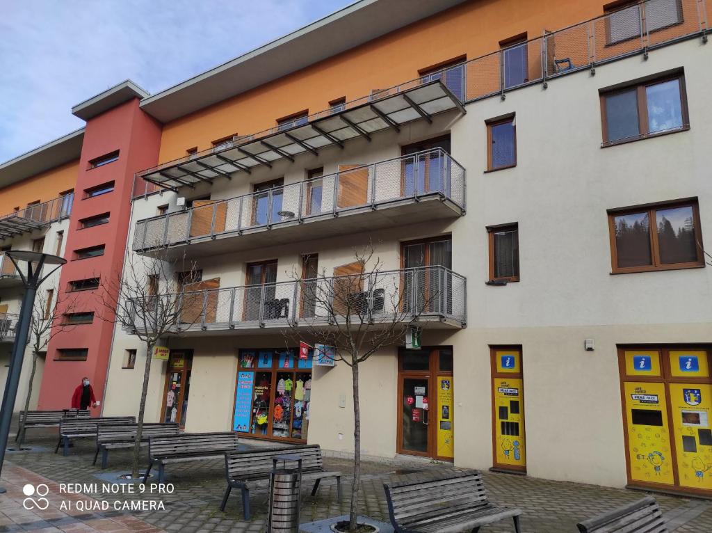 a building with benches in front of it at Apartmán Janka in Oščadnica