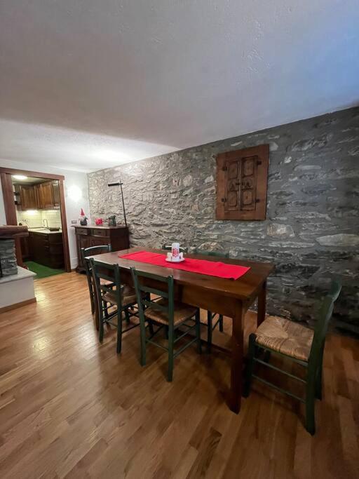uma sala de jantar com uma mesa vermelha e cadeiras em refuge du skieur cir 0051 em Courmayeur