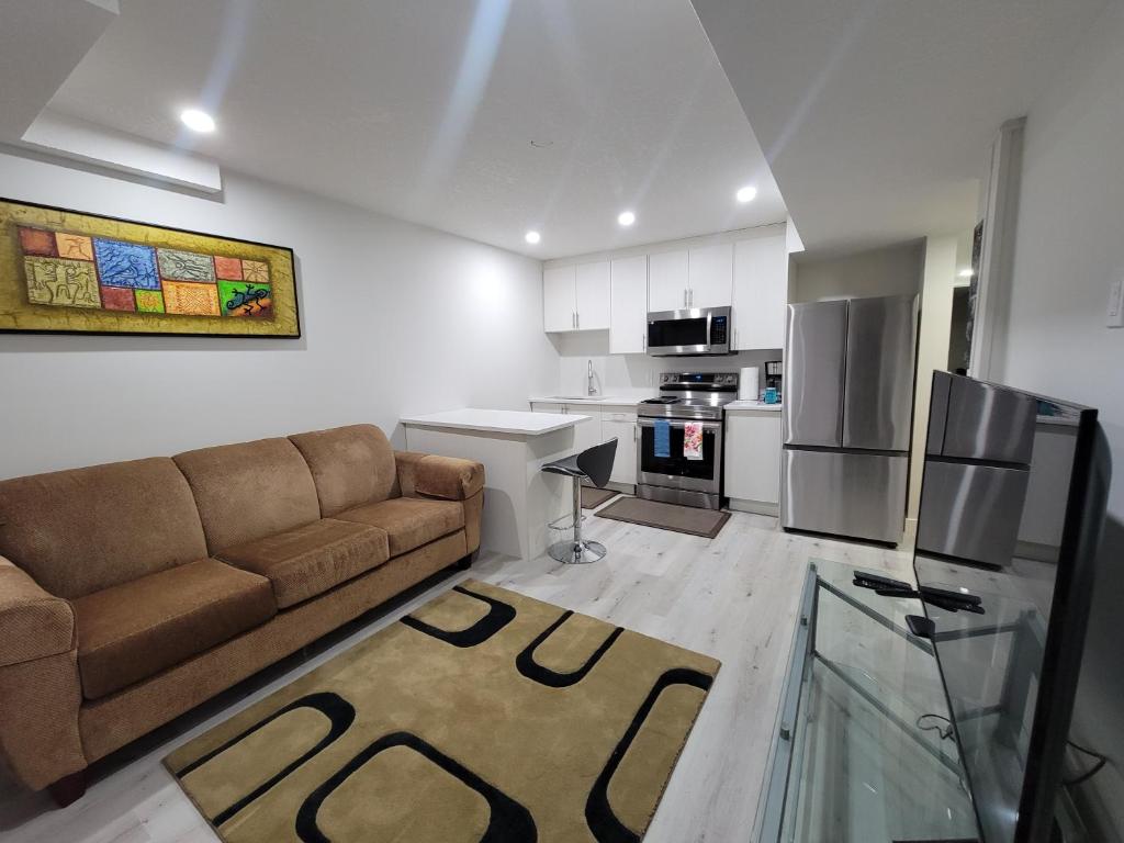 a living room with a couch and a kitchen at Walkout Basement Suite in Calgary