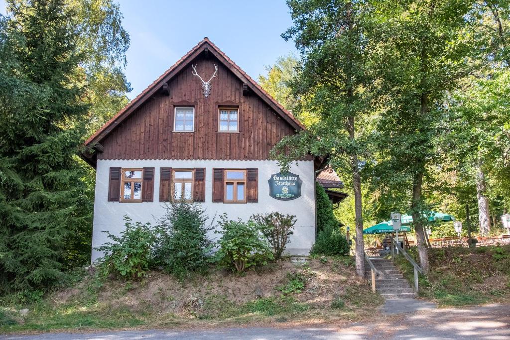 uma casa numa colina com árvores em FeWo im Gasthof Forsthaus em Marktredwitz