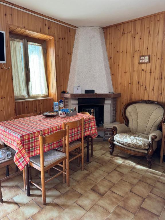 uma sala de jantar com uma mesa e uma lareira em Alloggio Turistico Casa di Luca e Vale em Campotosto