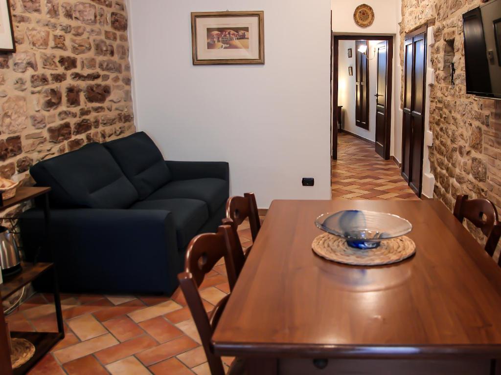 - un salon avec une table et un canapé dans l'établissement CASA ARMANNI - la tua Casa di Pietra, à Gubbio