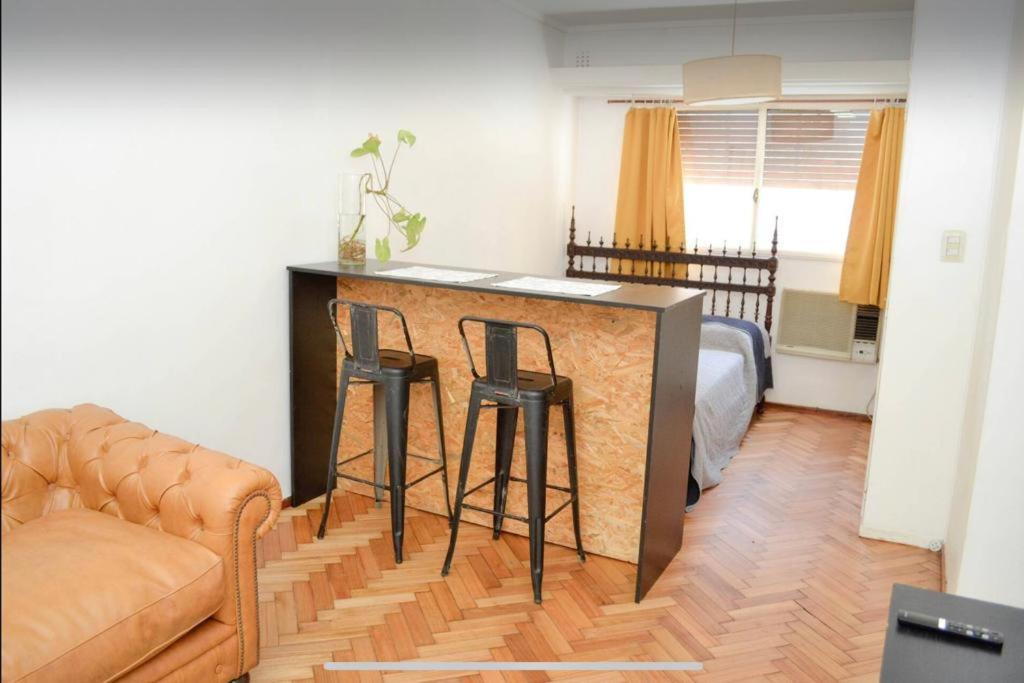 uma sala de estar com um sofá e dois bancos de bar em Don Pablo em Buenos Aires