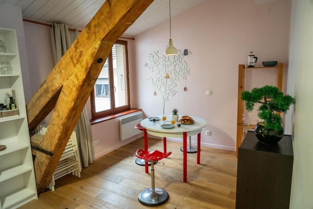 a living room with a table and a window at Escapade Annécienne in Annecy