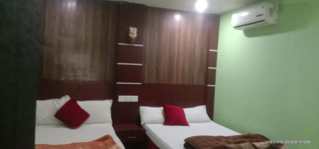 a bedroom with two beds with red pillows at Hotel ABC Pvt. Ltd. in Bhairahawa