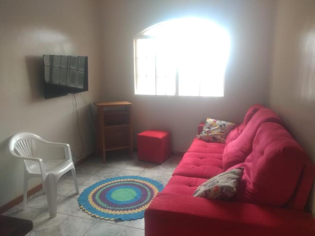 a living room with a red couch and a chair at Hospedaria Chaves in Brasília