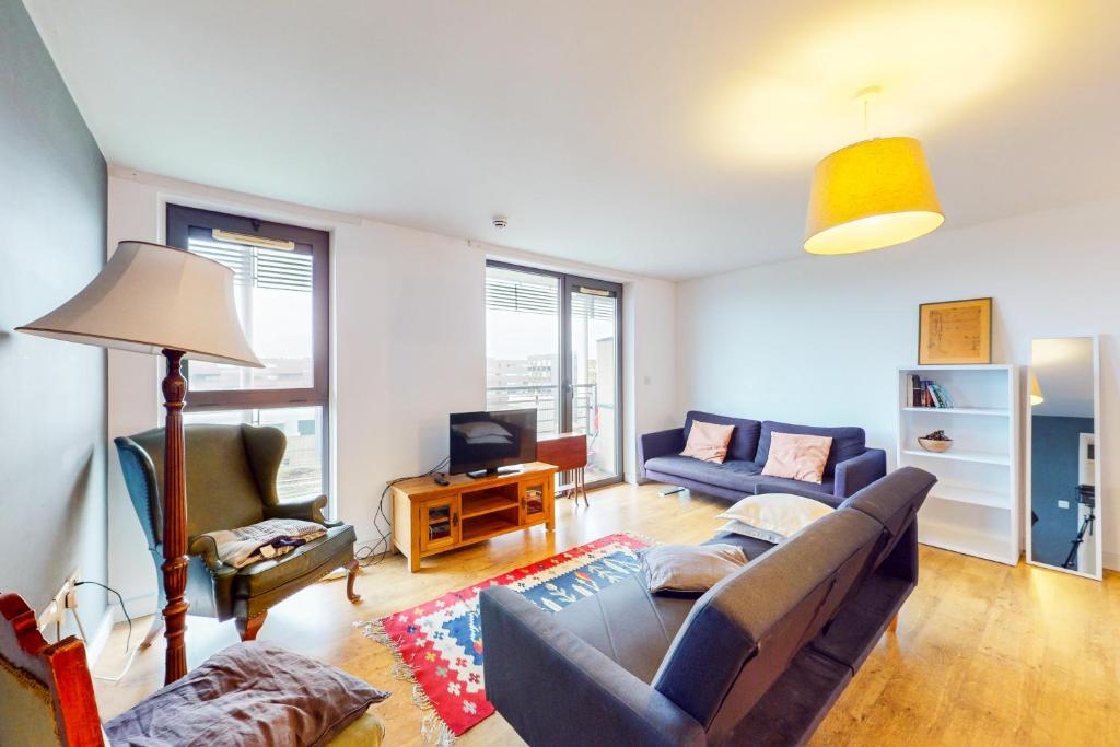 uma sala de estar com um sofá e uma televisão em Appealing 2 Bedroom apartment in Bethnal Green em Londres