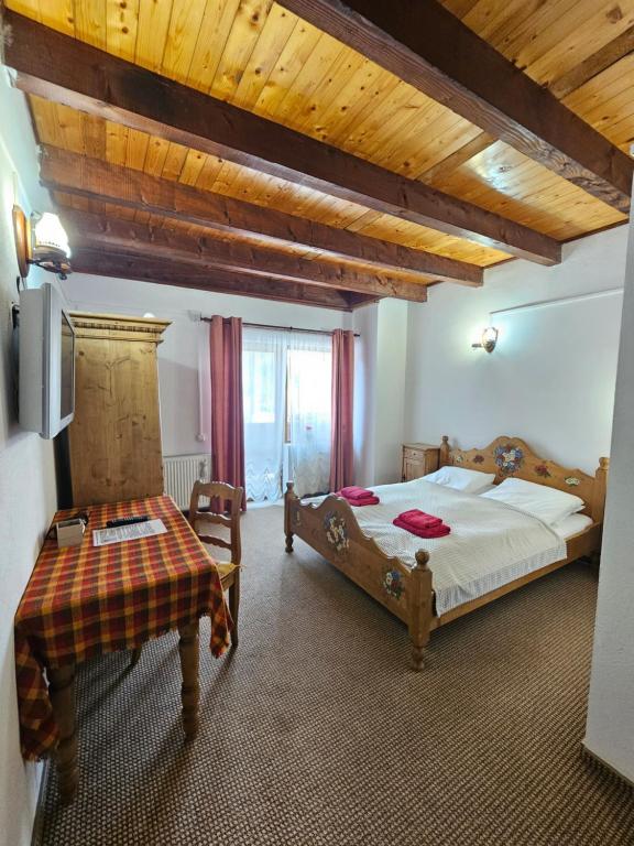 a bedroom with two beds and a wooden ceiling at Pensiunea Casa Gobbel in Bran