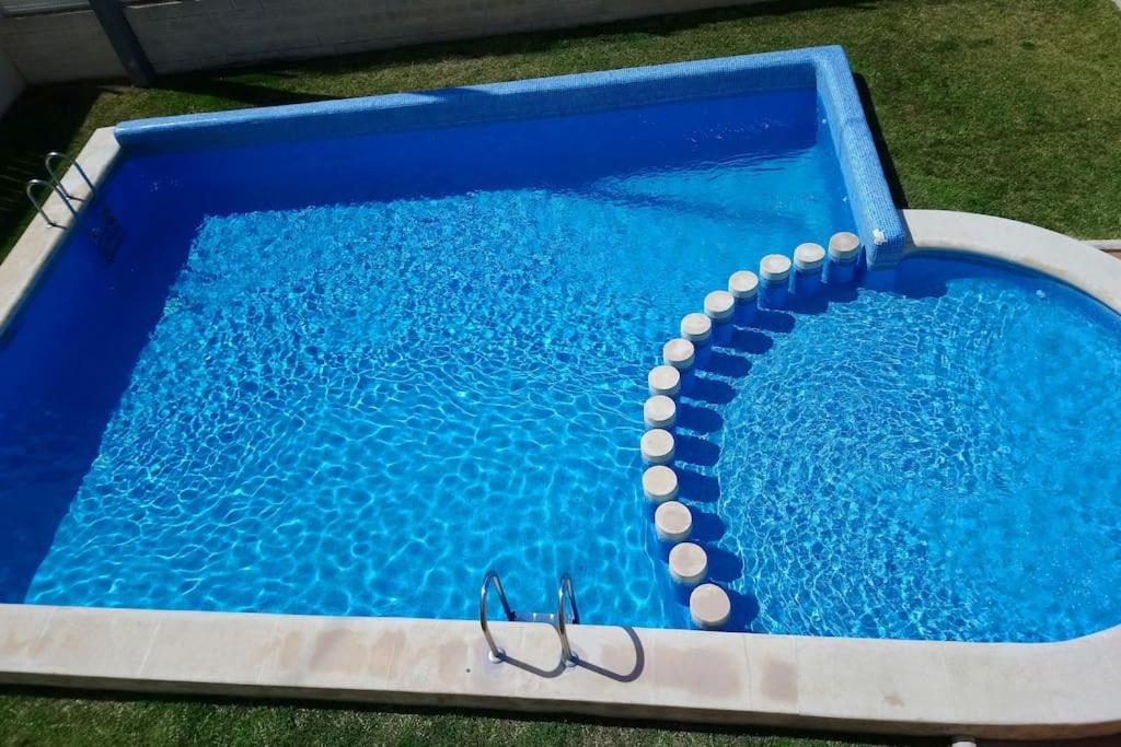 ein blauer Pool mit einer Brille darin in der Unterkunft Apartamento a 100 metros del mar in Piles