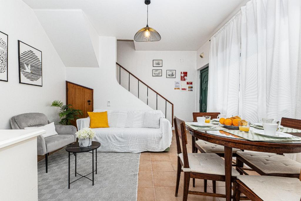 ein Wohnzimmer mit einem weißen Sofa und einem Tisch in der Unterkunft Casa Gaivota by Algarve Golden Properties in Lagos