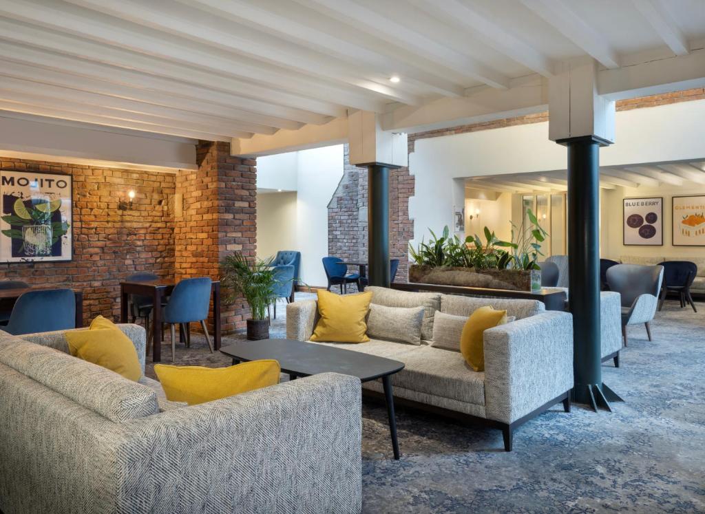 eine Lobby mit Sofas, Tischen und Stühlen in der Unterkunft Delta Hotels by Marriott Worsley Park Country Club in Worsley