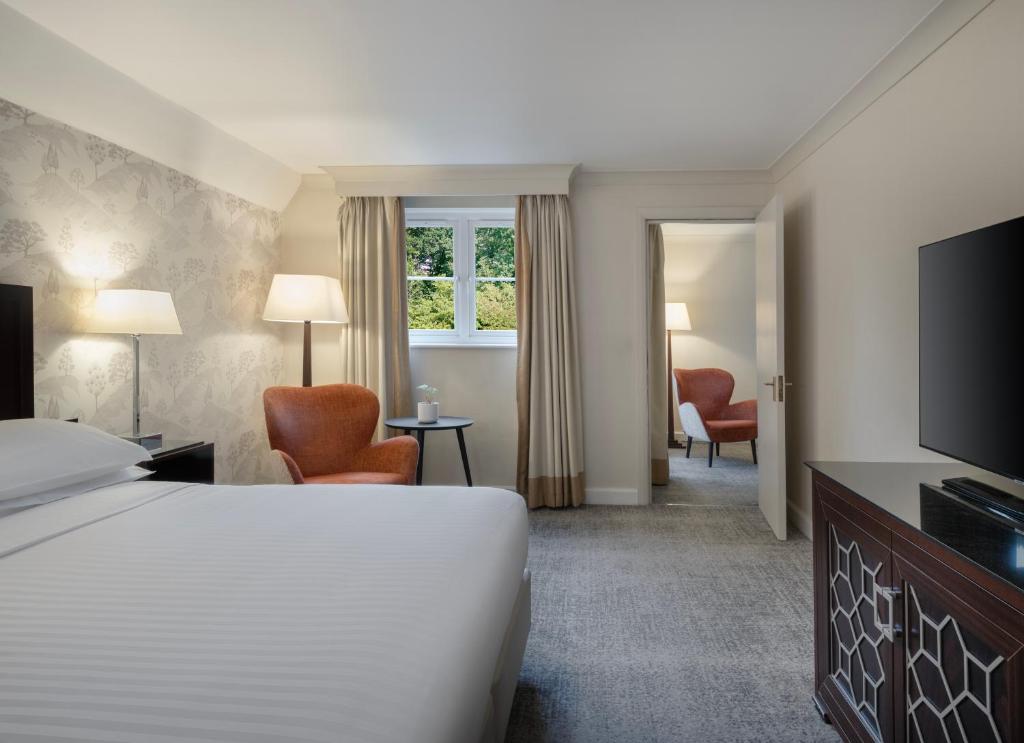 ウォースリーにあるDelta Hotels by Marriott Worsley Park Country Clubのベッドとテレビが備わるホテルルームです。