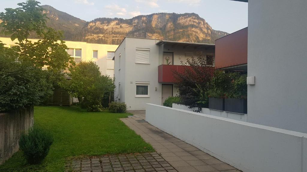 an apartment building with a yard and mountains in the background at Anna in Dornbirn