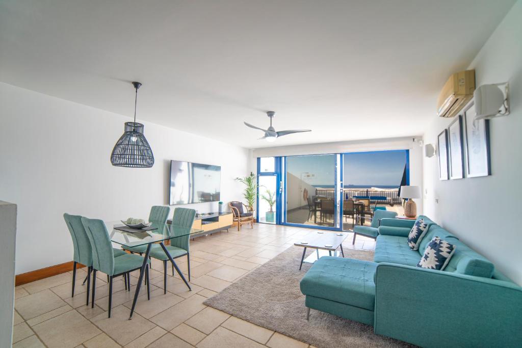 a living room with a blue couch and a table at Jasmin in Puerto Calero