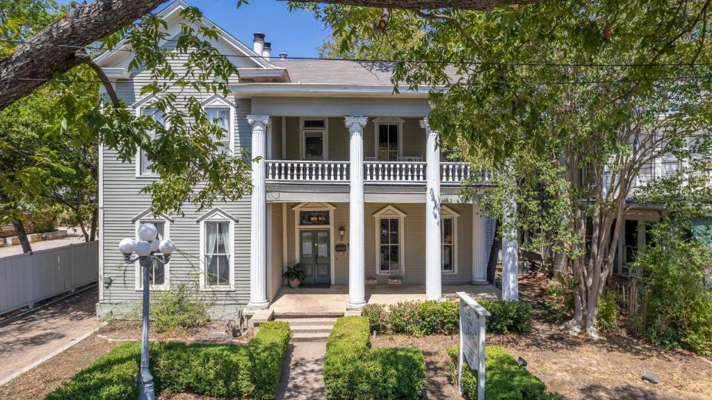 a white house with a porch and columns at Crystal River Inn in San Marcos