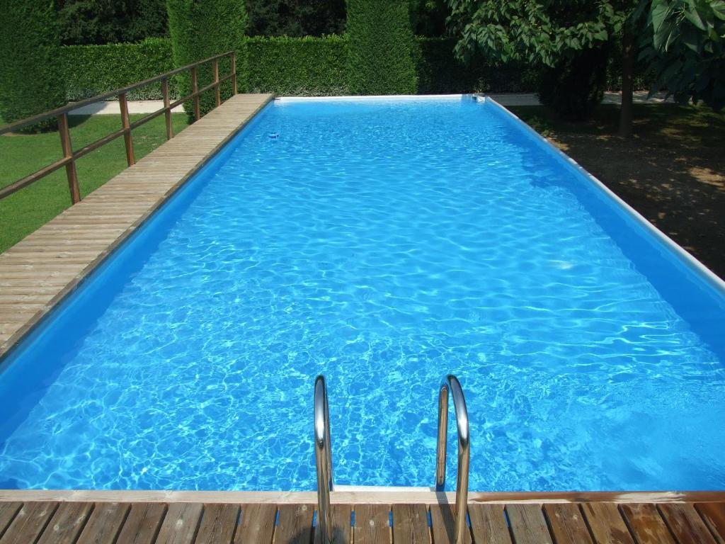 una grande piscina blu accanto a una terrazza in legno di Villa Moro Lin Design Apartments a Mestre