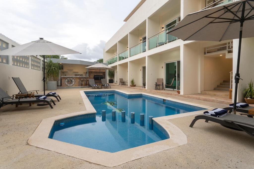 une piscine avec un parasol et un bâtiment dans l'établissement PETRAS HOTEL, à Brisas de Zicatela