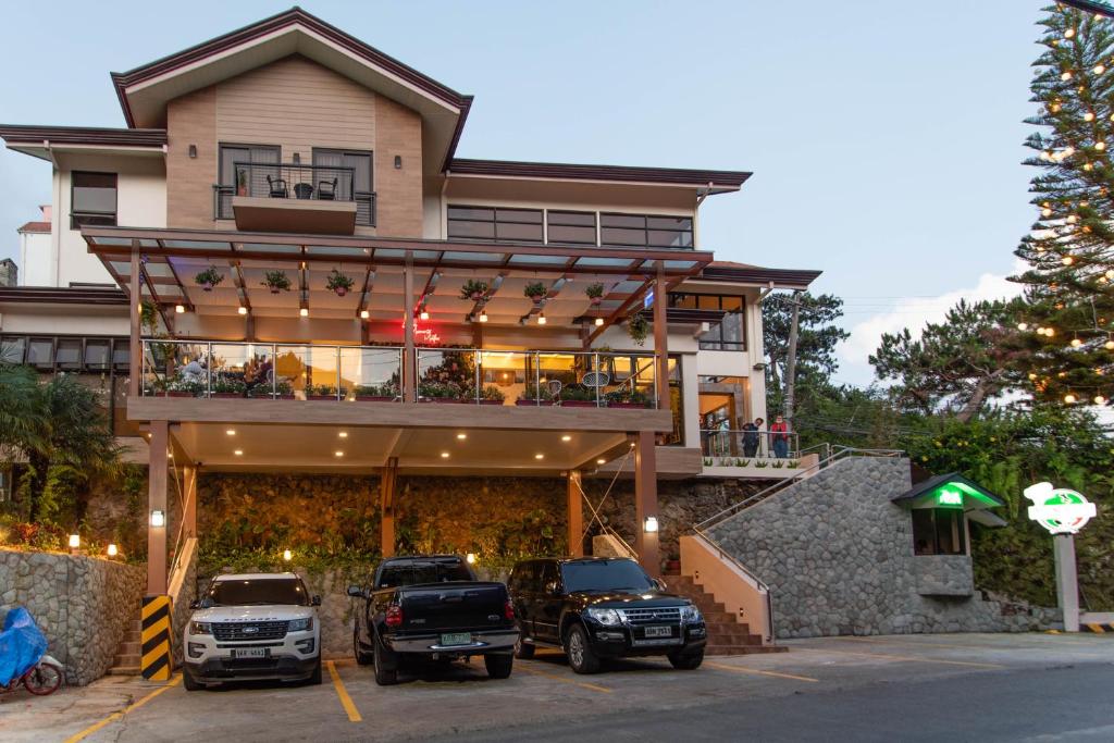 a house with two trucks parked in front of it at Giraffe Boutique Hotel in Baguio