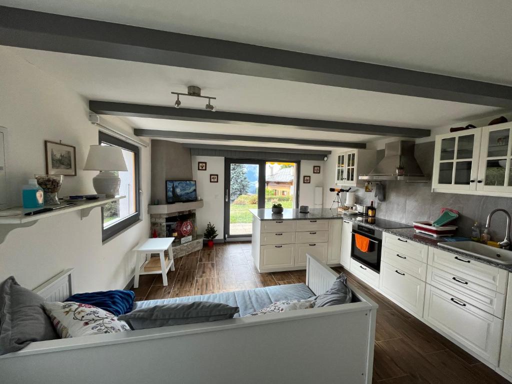 una cocina con armarios blancos y un sofá en una habitación en Appartement 2-pieces à Verbier, en Verbier