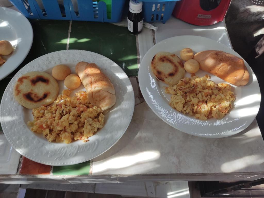 einen Tisch mit zwei Teller Essen und Brot in der Unterkunft Hospedaje los polos in Villavieja
