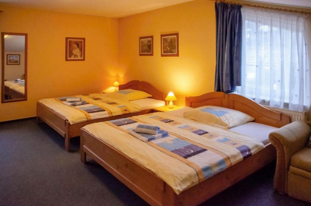 two beds in a room with yellow walls at JazzPenzion in Čadca