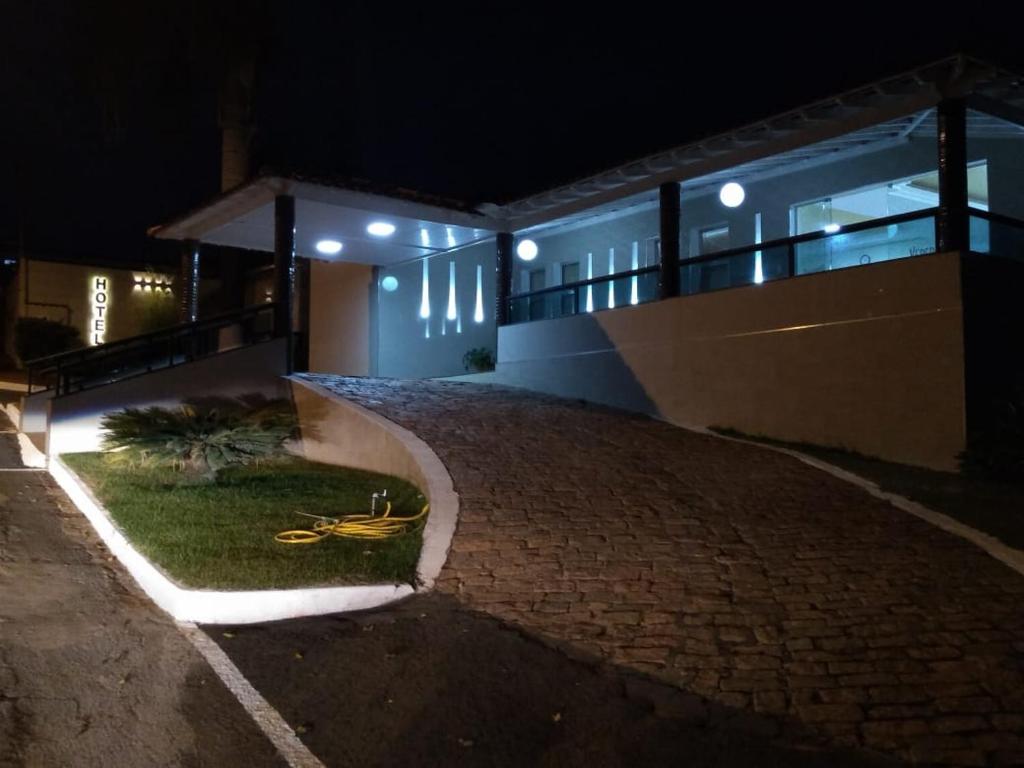 a building with a brick driveway in front of it at night at HOTEL VEREDAS in Monsenhor Paulo