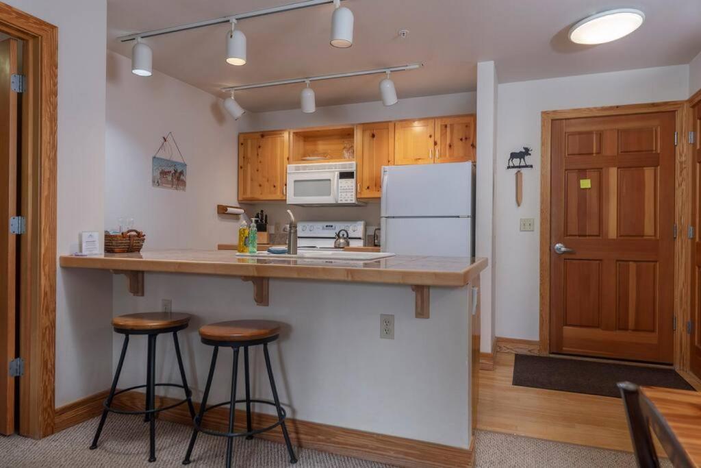 una cucina con bancone e sgabelli in una stanza di Condo Driggs - Bannock 212 a Driggs