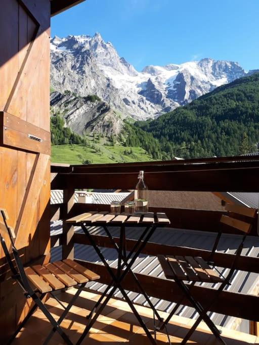 d'une table sur un balcon avec vue sur les montagnes. dans l'établissement Le Lodge - Au coeur du village, à La Grave