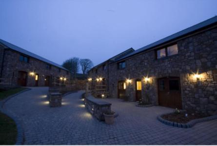 a stone building with two benches in front of it at King's Head Inn in Llangennith