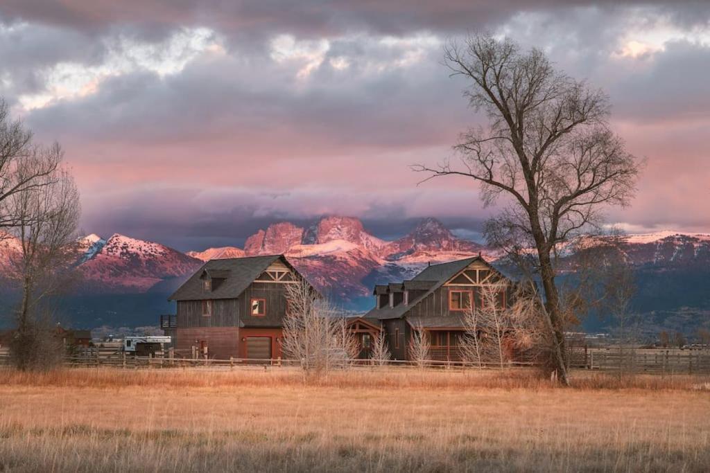 a house in a field with mountains in the background at Postcard Views, Teton Valley Id in Tetonia