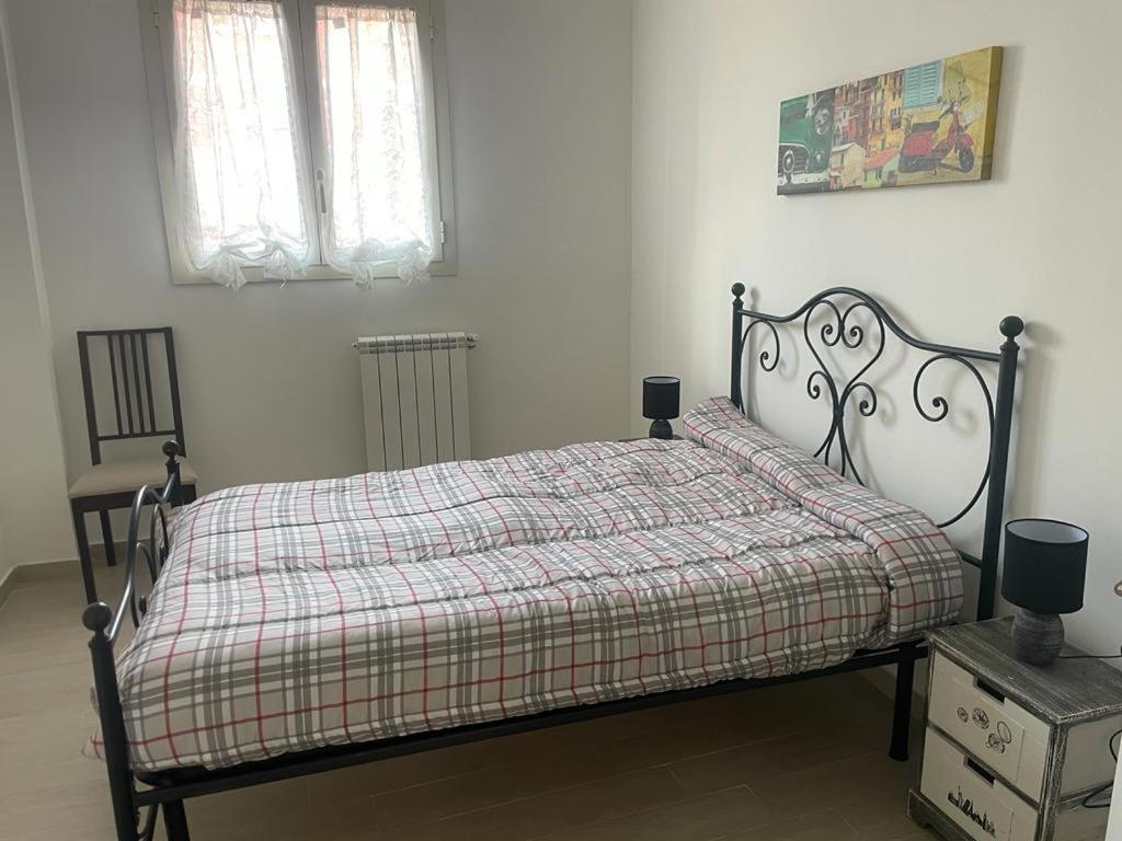 una camera da letto con un letto con una coperta a quadri e due finestre di BORGO PESCI a Roma