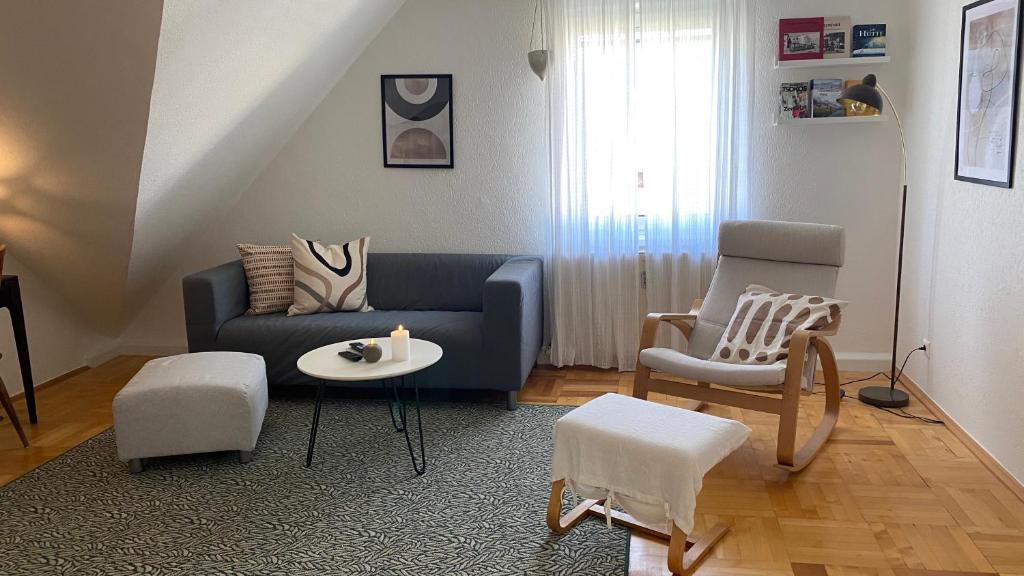 sala de estar con sofá azul y silla en Wohnung am Spitalberg, en Klagenfurt
