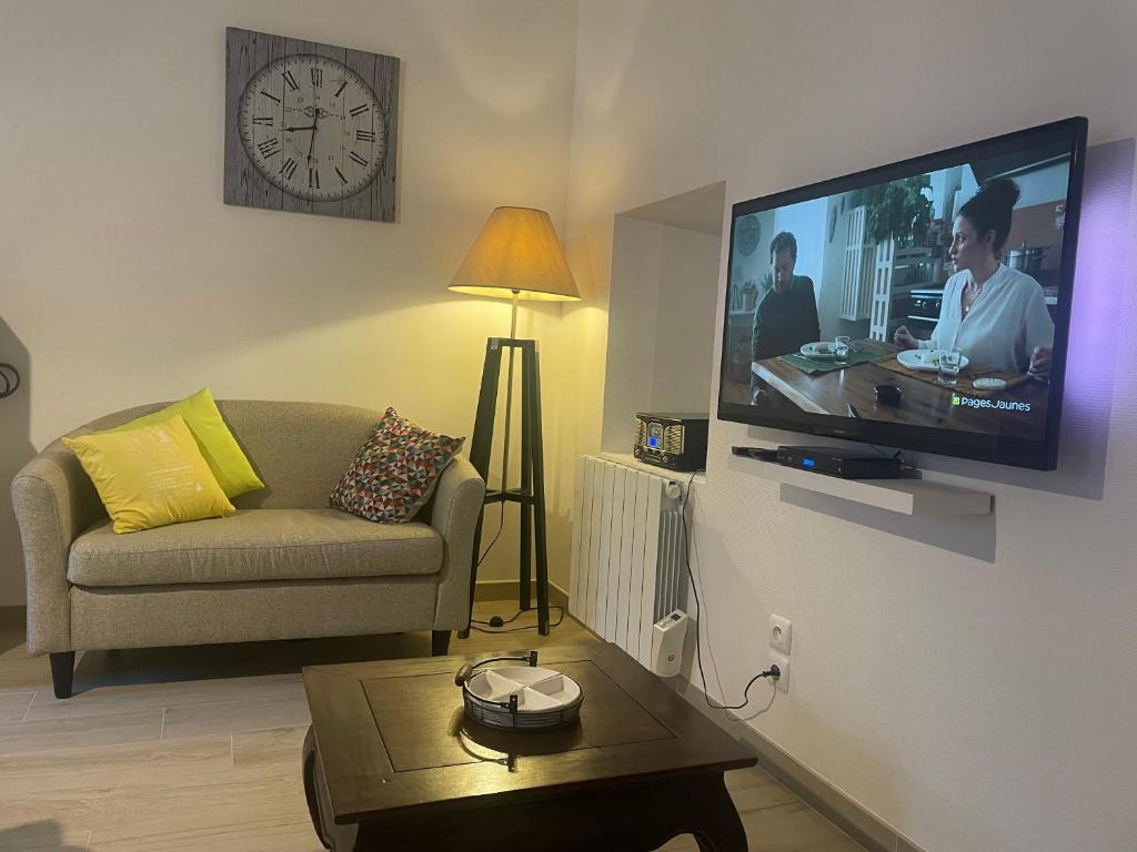un soggiorno con un divano e una TV a parete di Maison Moderne et Confortable centre Bretagne a Plouguenast Langast