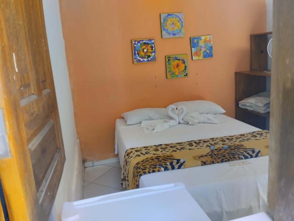 a small room with two beds and a door at João de Barro Hospedagem in Caeté-Açu