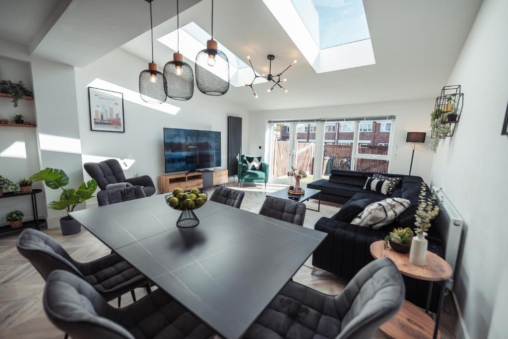 ein Wohnzimmer mit einem Tisch und Stühlen in der Unterkunft Exquisite 6 Bedroom Luxury Home Manchester in Manchester