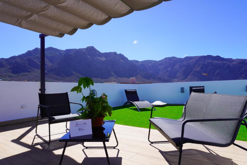 a patio with chairs and a view of mountains at El Miramar in Buenavista del Norte