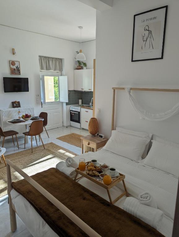a living room with a white bed and a table at The Valkyries 1 in Leonidio